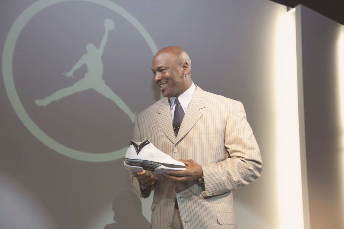 Майкл Джордан держит кроссовки своего бренда